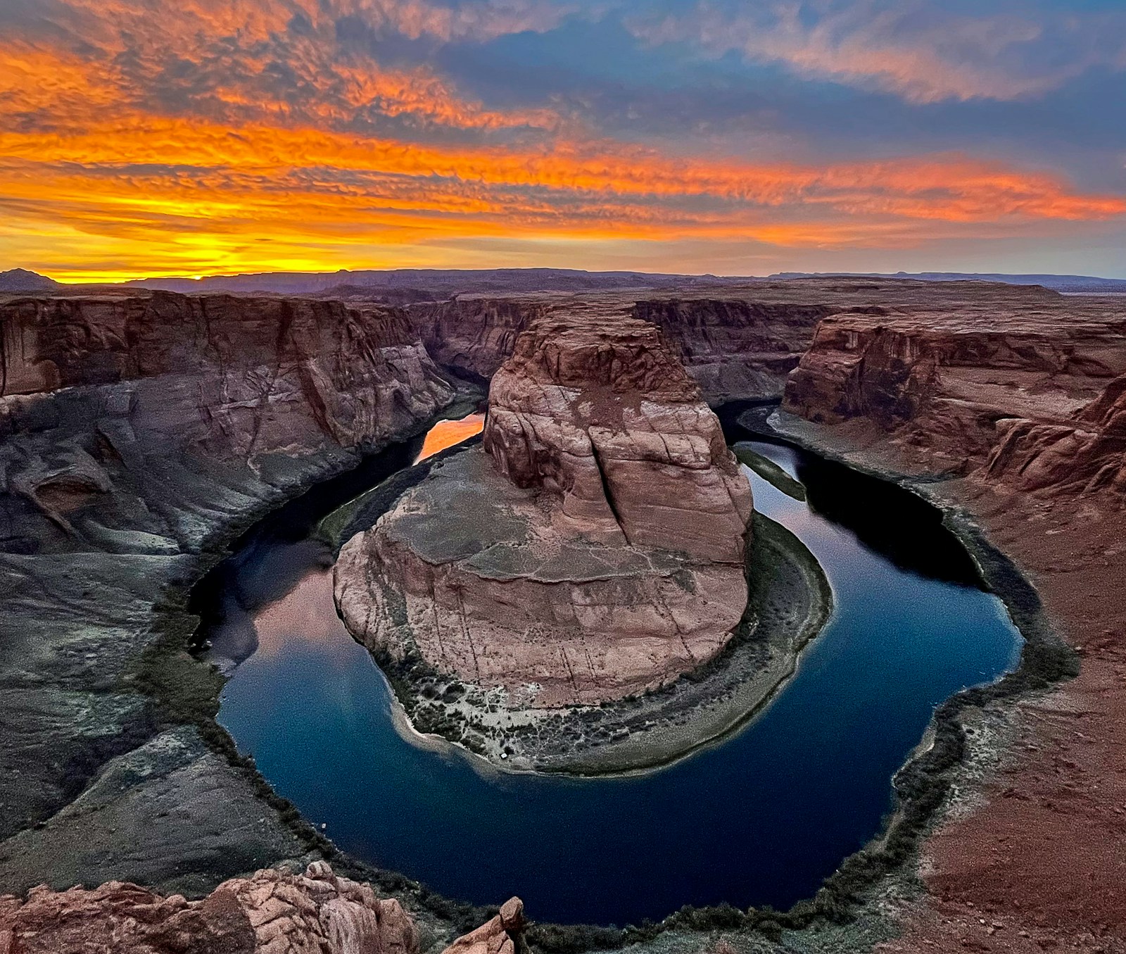 A river winding through a deep sandstone canyon at dusk.