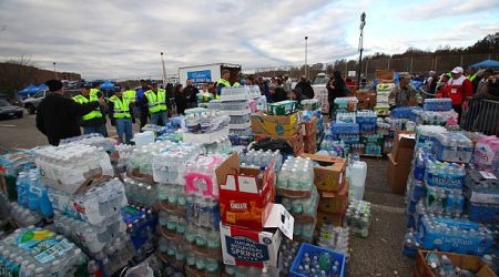Статен-Айленд - Нью-Йорк - США - 4 ноября 2012 года: Национальная гвардия и Красный Крест привезли тонны припасов в среднюю школу Нью-Дорп, чтобы помочь жертвам урагана &quot;Сэнди&quot;. Груды воды в бутылках сложены для раздачи